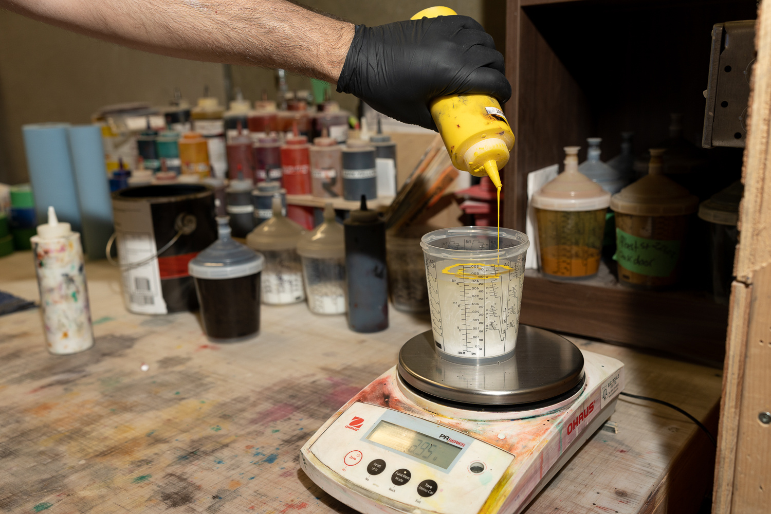 Blake applying water-borne paint in Platinum Pro-Claim’s in-house cabinet shop using an eco-friendly spray system